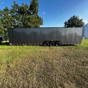 a black trailer in a grassy field