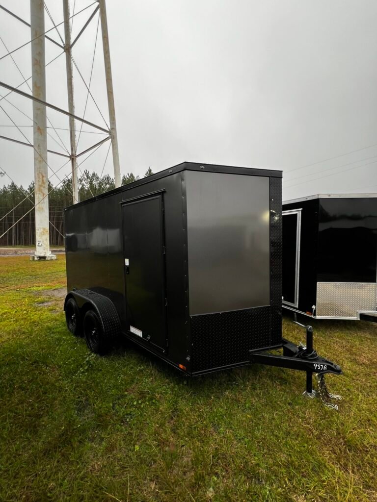 a black tandem axle trailer on grass