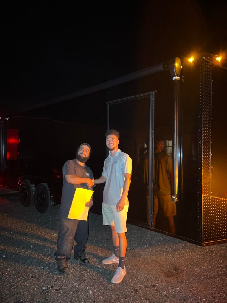 two men standing in front of a black building